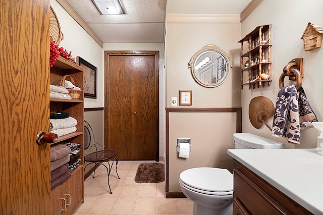 bathroom featuring tile flooring, vanity, and toilet