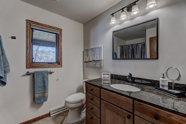 bathroom featuring tile flooring, toilet, and vanity with extensive cabinet space