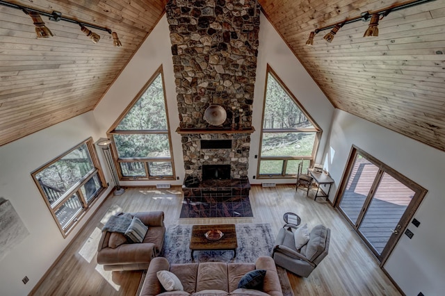 unfurnished living room with high vaulted ceiling, plenty of natural light, and wooden ceiling