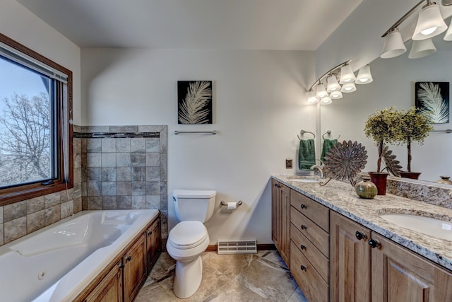 bathroom with a washtub, tile flooring, toilet, and double sink vanity