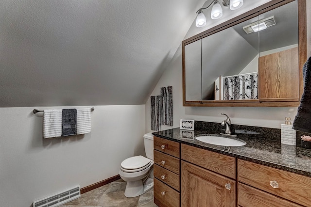 bathroom with tile flooring, lofted ceiling, vanity, and toilet