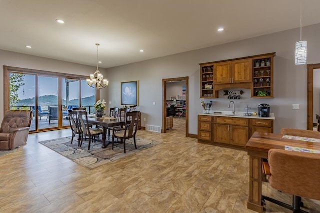 dining area with a mountain view, light tile flooring, sink, and a chandelier