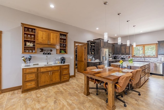 kitchen with tasteful backsplash, pendant lighting, light tile floors, a center island, and appliances with stainless steel finishes