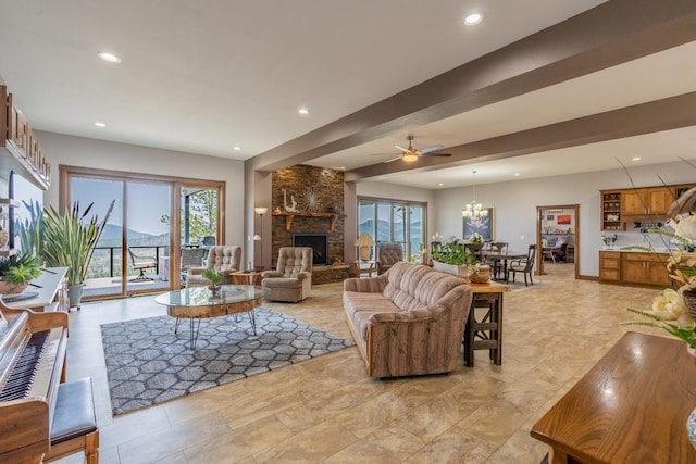 living room featuring a stone fireplace, ceiling fan with notable chandelier, a healthy amount of sunlight, and light tile floors