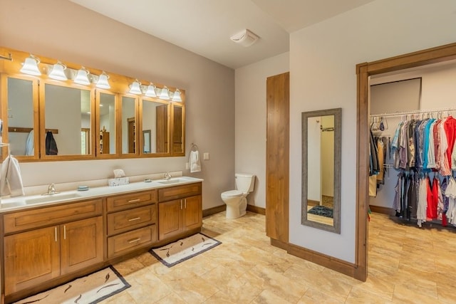 bathroom featuring tile floors, vanity with extensive cabinet space, toilet, and double sink