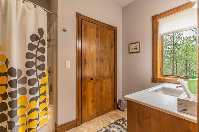 bathroom featuring shower / bath combo with shower curtain, tile flooring, and vanity