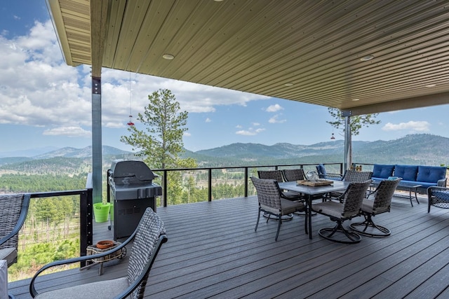 wooden deck featuring area for grilling, an outdoor living space, and a mountain view