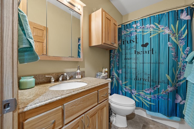 bathroom featuring tile flooring, toilet, and vanity