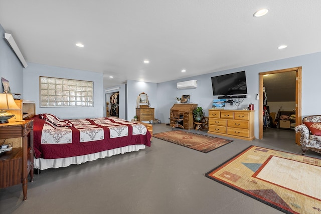 bedroom with a wall mounted AC, a closet, and concrete flooring