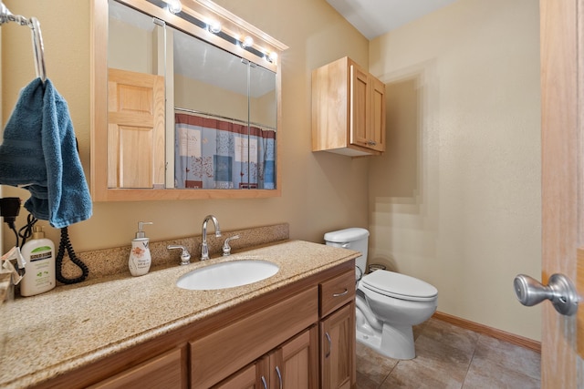 bathroom featuring tile flooring, vanity, and toilet