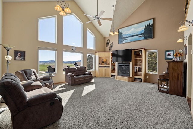 living room with high vaulted ceiling, ceiling fan with notable chandelier, and carpet flooring