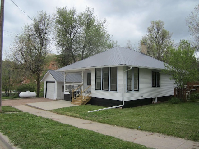 view of front of home with a garage, a front lawn, and an outdoor structure