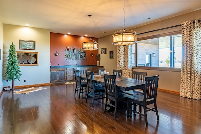 dining space featuring dark hardwood / wood-style flooring and a chandelier