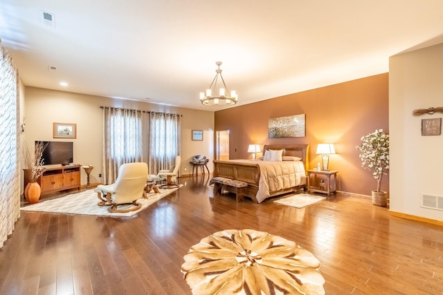 bedroom with an inviting chandelier and hardwood / wood-style floors