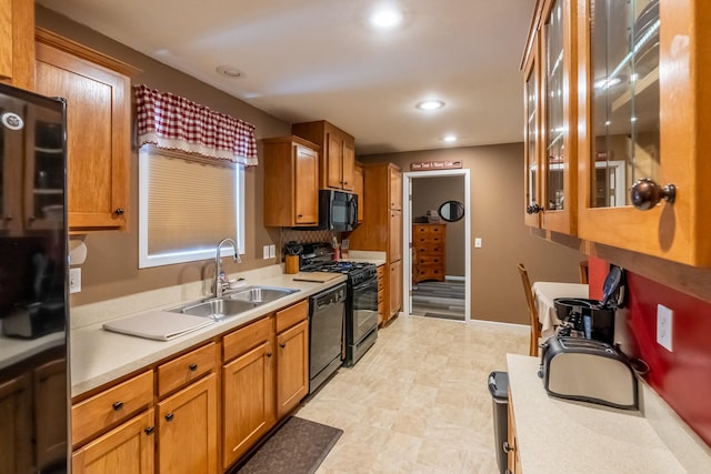 kitchen featuring black appliances, sink, and light tile floors