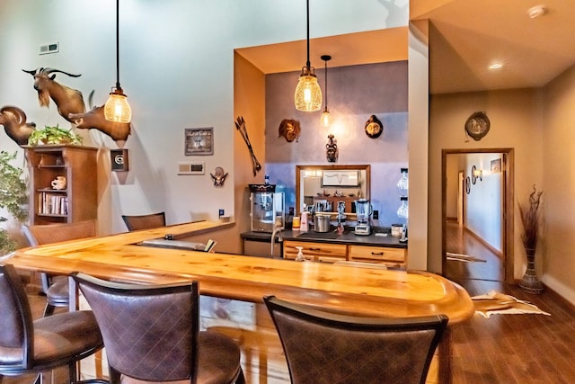 bar with hardwood / wood-style flooring and butcher block counters