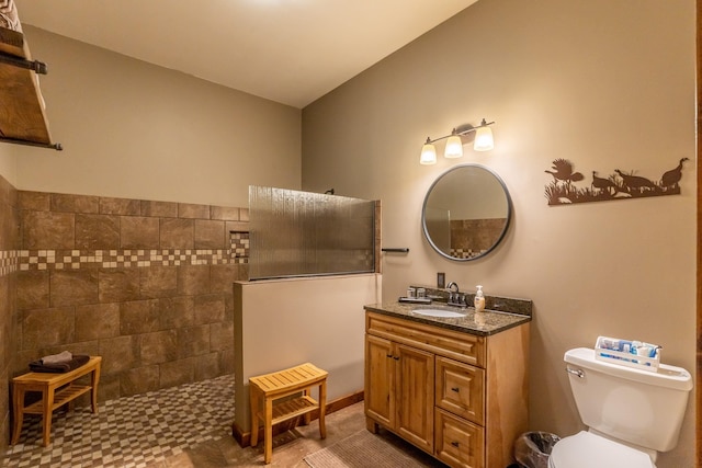 bathroom featuring walk in shower, vanity, toilet, and tile floors