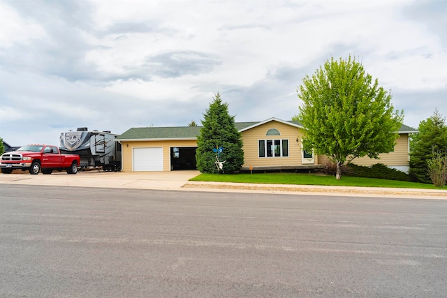 single story home with a garage and a front lawn