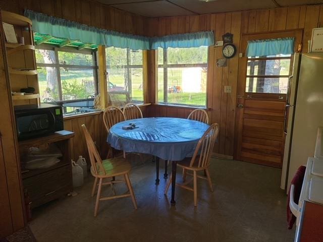 dining room with plenty of natural light and wooden walls