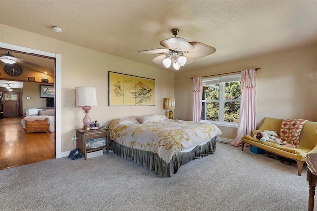 bedroom with ceiling fan, wood-type flooring, and vaulted ceiling