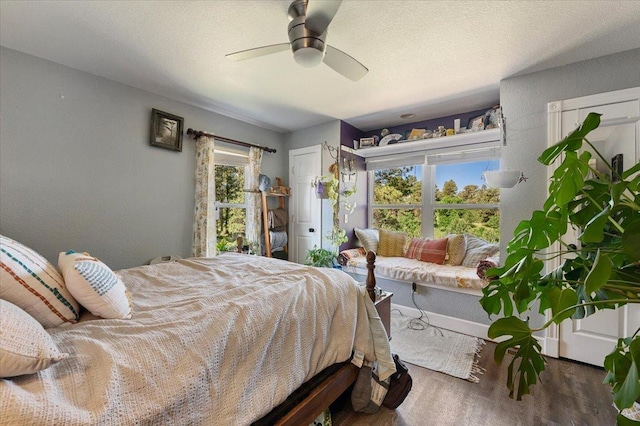 bedroom featuring ceiling fan, dark hardwood / wood-style floors, and a textured ceiling