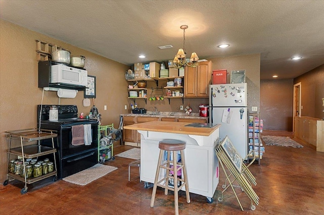 kitchen featuring butcher block counters, an inviting chandelier, a textured ceiling, white appliances, and a kitchen bar