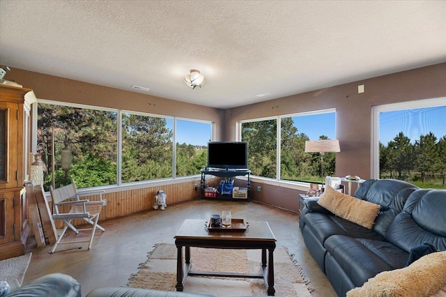 living room featuring wooden walls and a textured ceiling