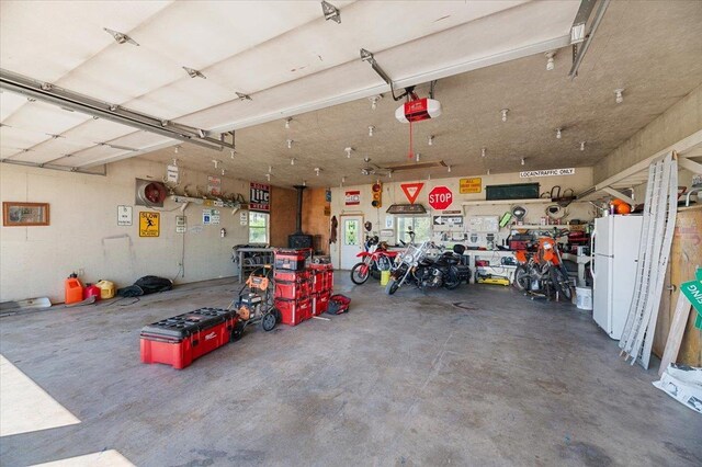 garage featuring white fridge and a garage door opener