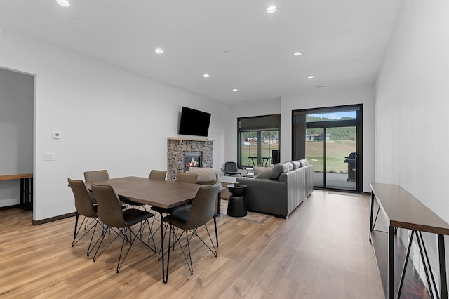 dining room with light hardwood / wood-style floors and a fireplace