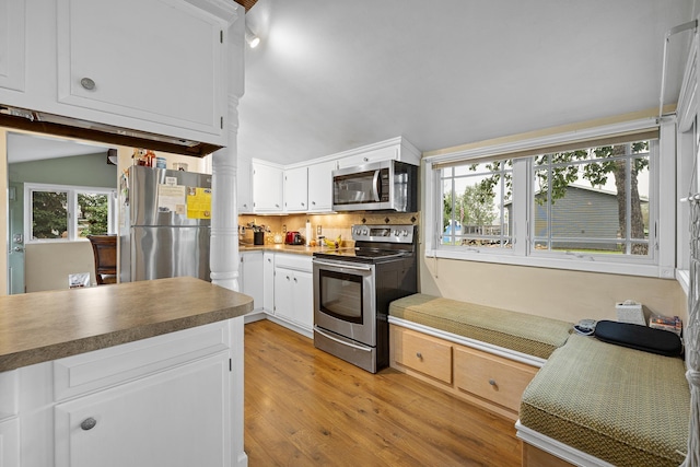 kitchen featuring white cabinets, appliances with stainless steel finishes, backsplash, and light wood-type flooring