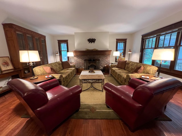 living room featuring plenty of natural light, hardwood / wood-style flooring, and a brick fireplace