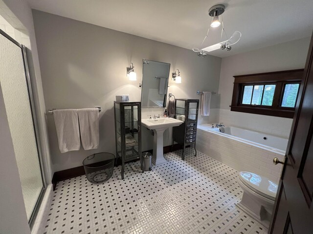 full bathroom featuring tile floors, sink, shower with separate bathtub, and toilet