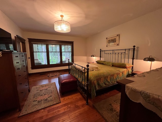 bedroom with an inviting chandelier and wood-type flooring