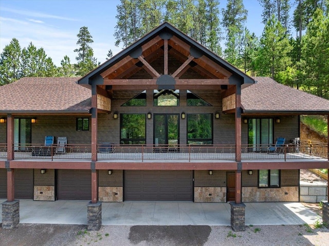 rear view of house with a balcony and a garage