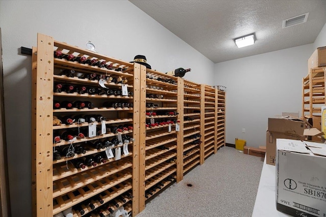 wine area with carpet floors and a textured ceiling