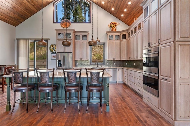 kitchen with stainless steel appliances, wood ceiling, a center island, and high vaulted ceiling