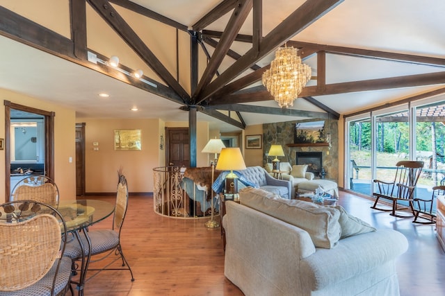 11504 Melchert Pl, Hill City, SD 57745 - living room with beamed ceiling, wood finished floors, a stone fireplace, baseboards, and a chandelier