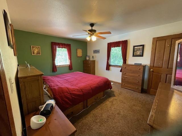 bedroom with dark colored carpet and ceiling fan