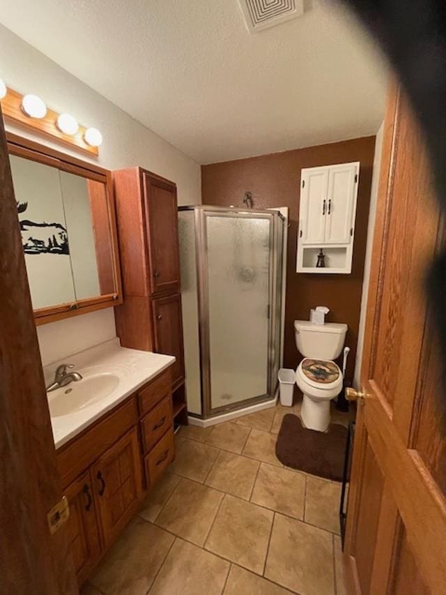 bathroom with vanity, a shower with door, tile patterned floors, toilet, and a textured ceiling