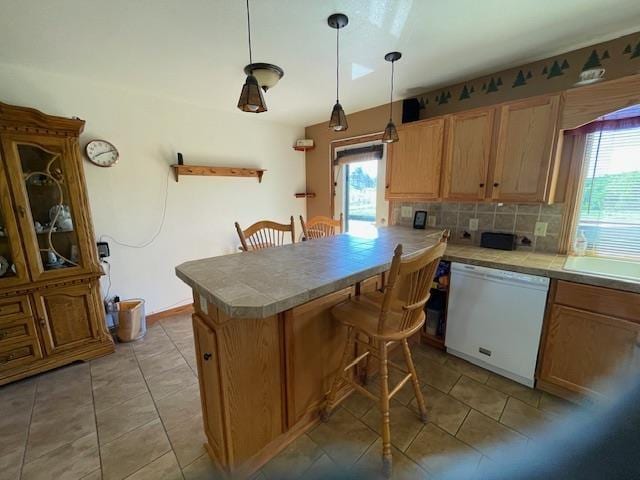 kitchen featuring dishwasher, a healthy amount of sunlight, kitchen peninsula, and a breakfast bar area