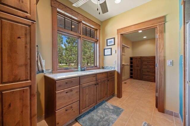 interior space with light tile patterned flooring, sink, and ceiling fan