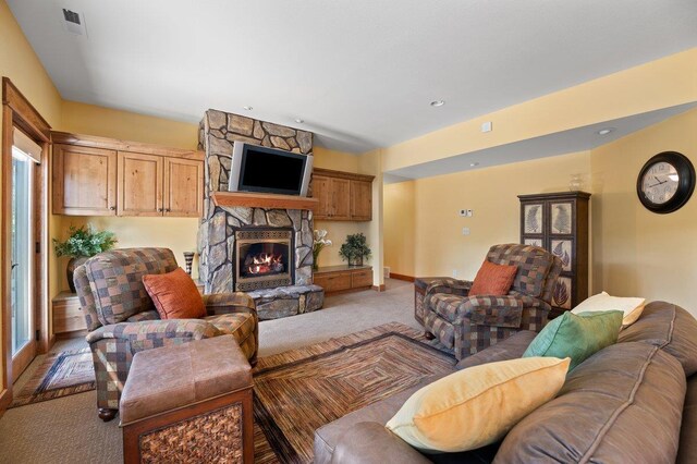 living room featuring carpet floors and a stone fireplace