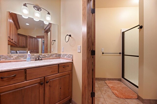 bathroom with a shower with shower door, tile patterned floors, tasteful backsplash, and vanity