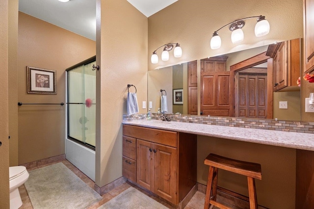 full bathroom with vanity, toilet, tile patterned floors, and tasteful backsplash