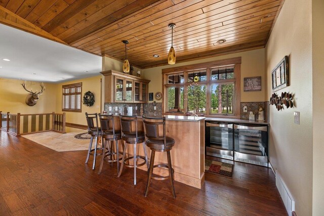 bar with wood-type flooring, decorative light fixtures, tasteful backsplash, and wooden ceiling