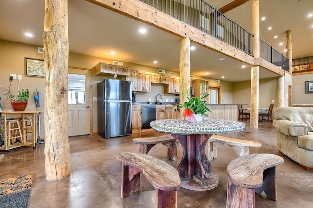 dining space featuring sink and a towering ceiling