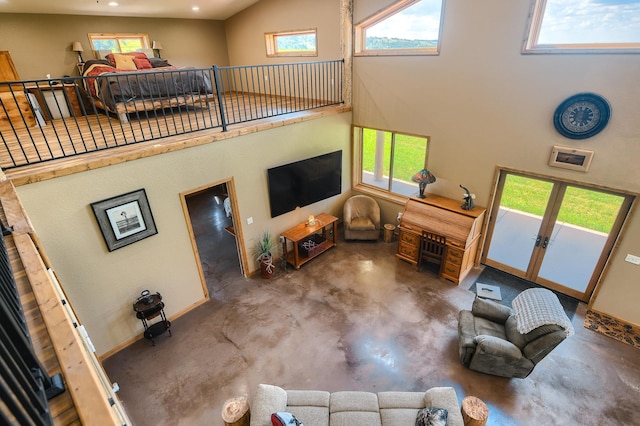 living room featuring concrete flooring and a high ceiling