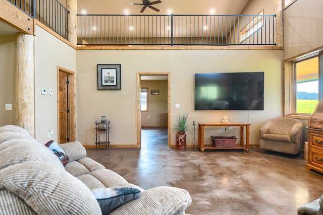 living room with a high ceiling, concrete floors, and ceiling fan