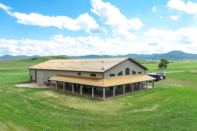 rear view of property featuring a mountain view, a patio area, and a rural view