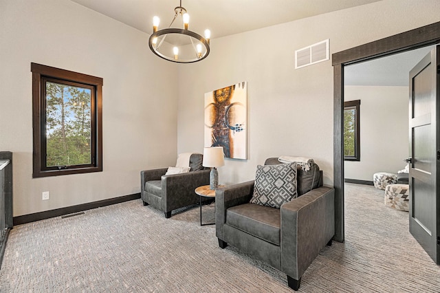 sitting room featuring a notable chandelier, carpet floors, and vaulted ceiling